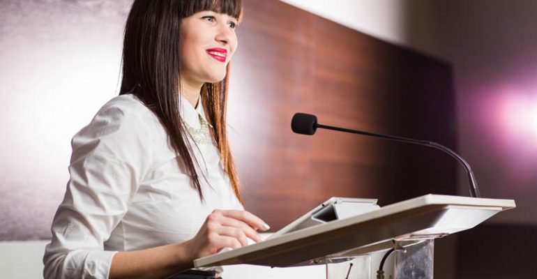 Pretty,,Young,Business,Woman,Giving,A,Presentation,In,A,Conference/meeting
